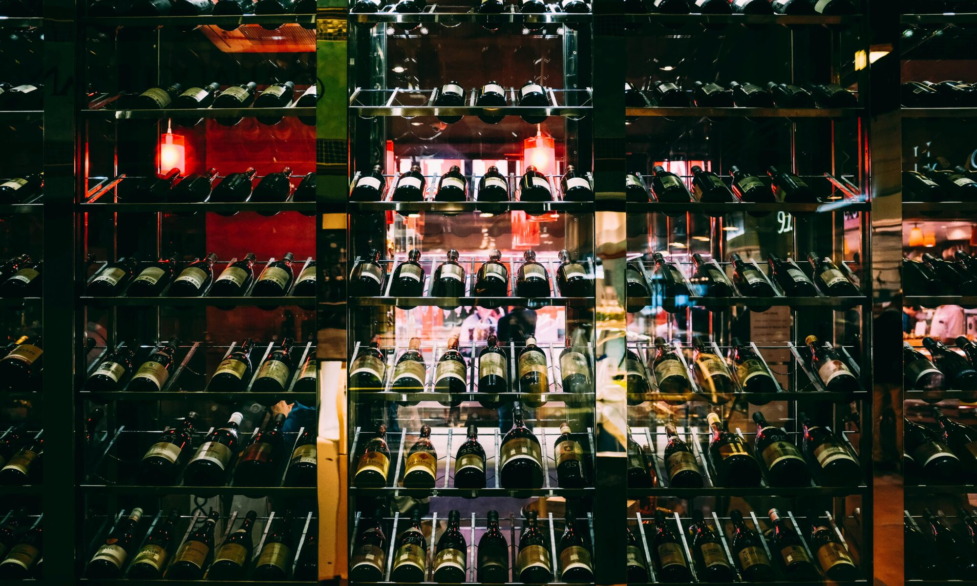 Rows of wine bottles elegantly displayed on shelves at an upscale bar, creating a luxurious ambiance.